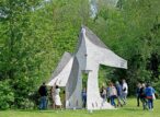 Groupe de personnes autour d'une grande sculpture extérieure.