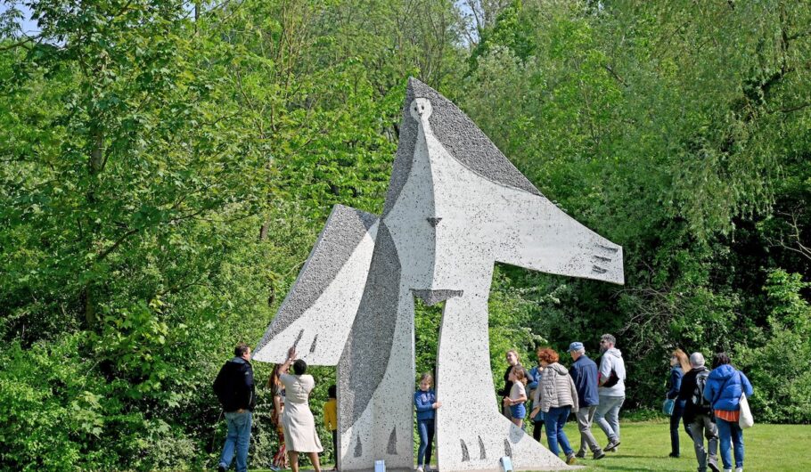 Groupe de personnes autour d'une grande sculpture extérieure.