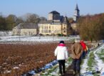 Randonneurs près d’une église et d’un château enneigés
