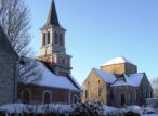 Église et bâtiments historiques enneigés sous ciel bleu