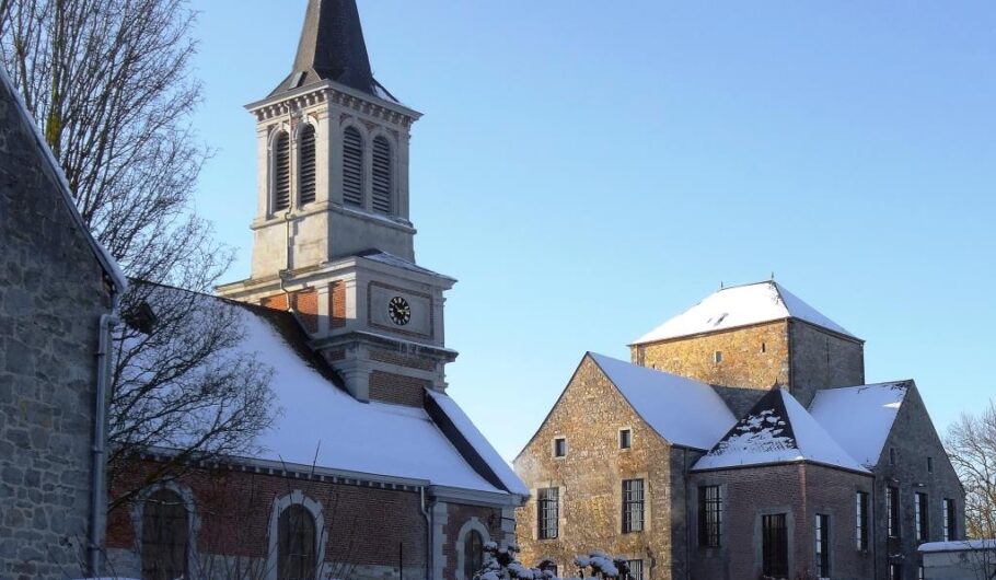 Église et bâtiments historiques enneigés sous ciel bleu