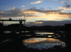 Portique industriel silhouetté au coucher du soleil