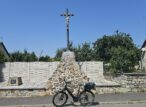 Vélo devant calvaire en pierre sous ciel bleu
