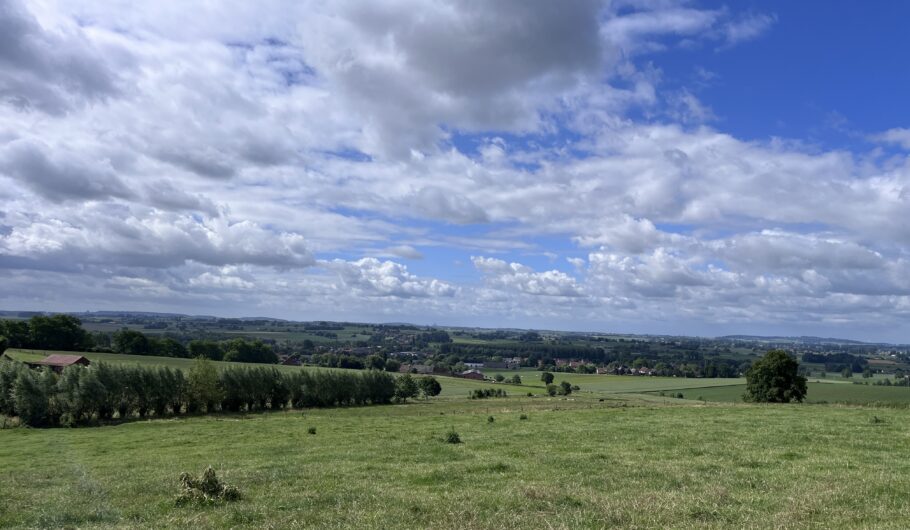 Paysage rural vallonné sous ciel nuageux