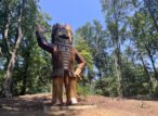 Grande statue en bois couronnée en forêt