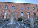 Monuments funéraires devant un bâtiment en briques rouges