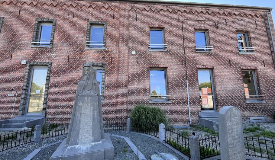 Monuments funéraires devant un bâtiment en briques rouges