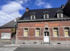 Maison en briques avec lucarnes sous ciel bleu
