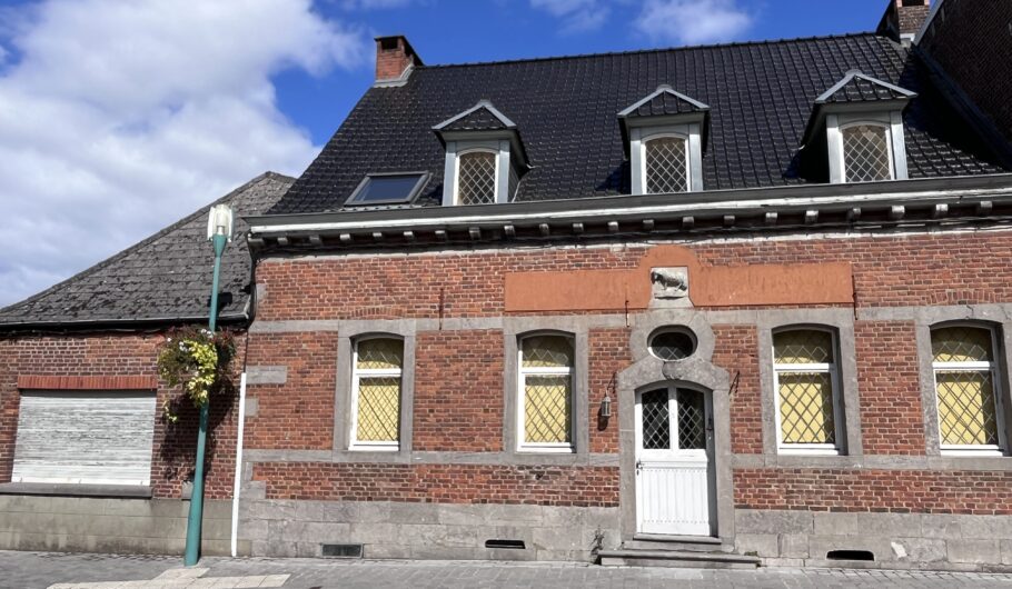 Maison en briques avec lucarnes sous ciel bleu