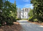 Allée arborée menant à une villa blanche rénovée