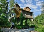 Cabane perchée avec toboggan métallique dans un jardin
