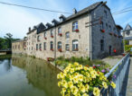 Maisons en pierre au bord d’un canal fleuri