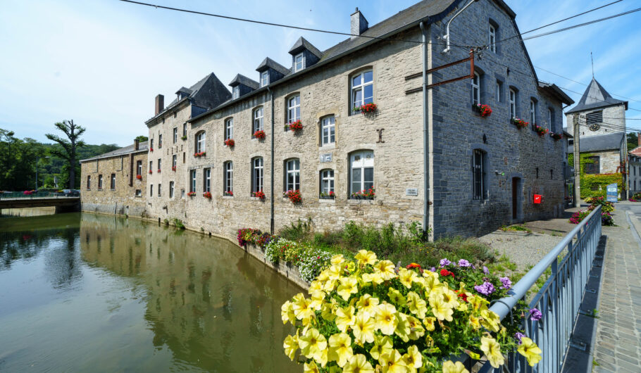 Maisons en pierre au bord d’un canal fleuri
