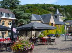 Terrasse de café devant une église dans un village verdoyant