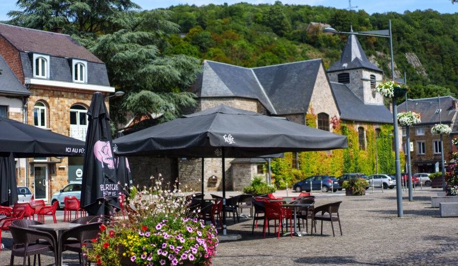 Terrasse de café devant une église dans un village verdoyant
