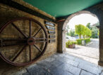 Grande roue de forge sous une arche en pierre