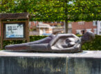 Sculpture en bronze d’une femme allongée dans un jardin